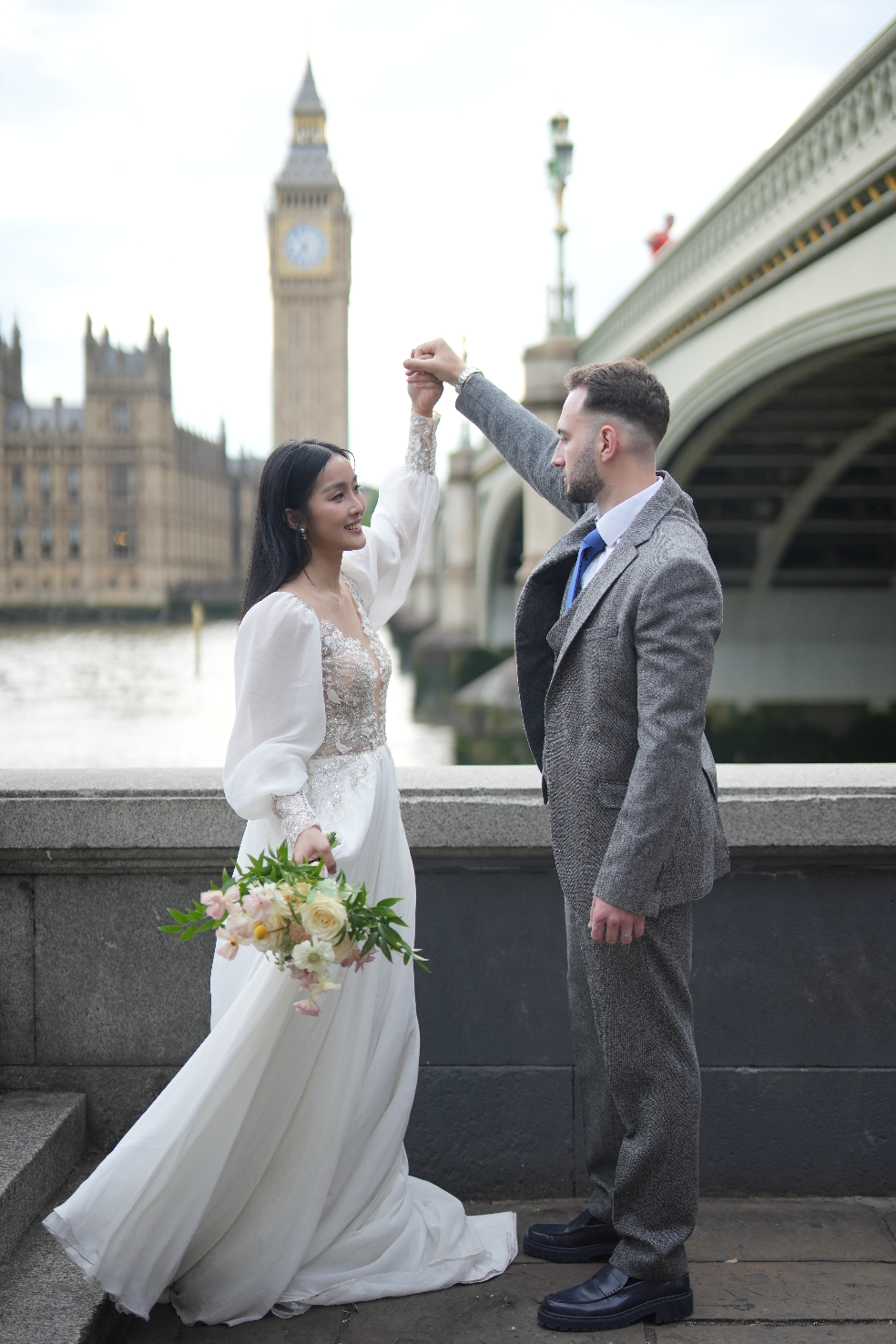 Bride wearing a bespoke ForeverTies wedding dress with the groom near Westminster Bridge and Big Ben in London.