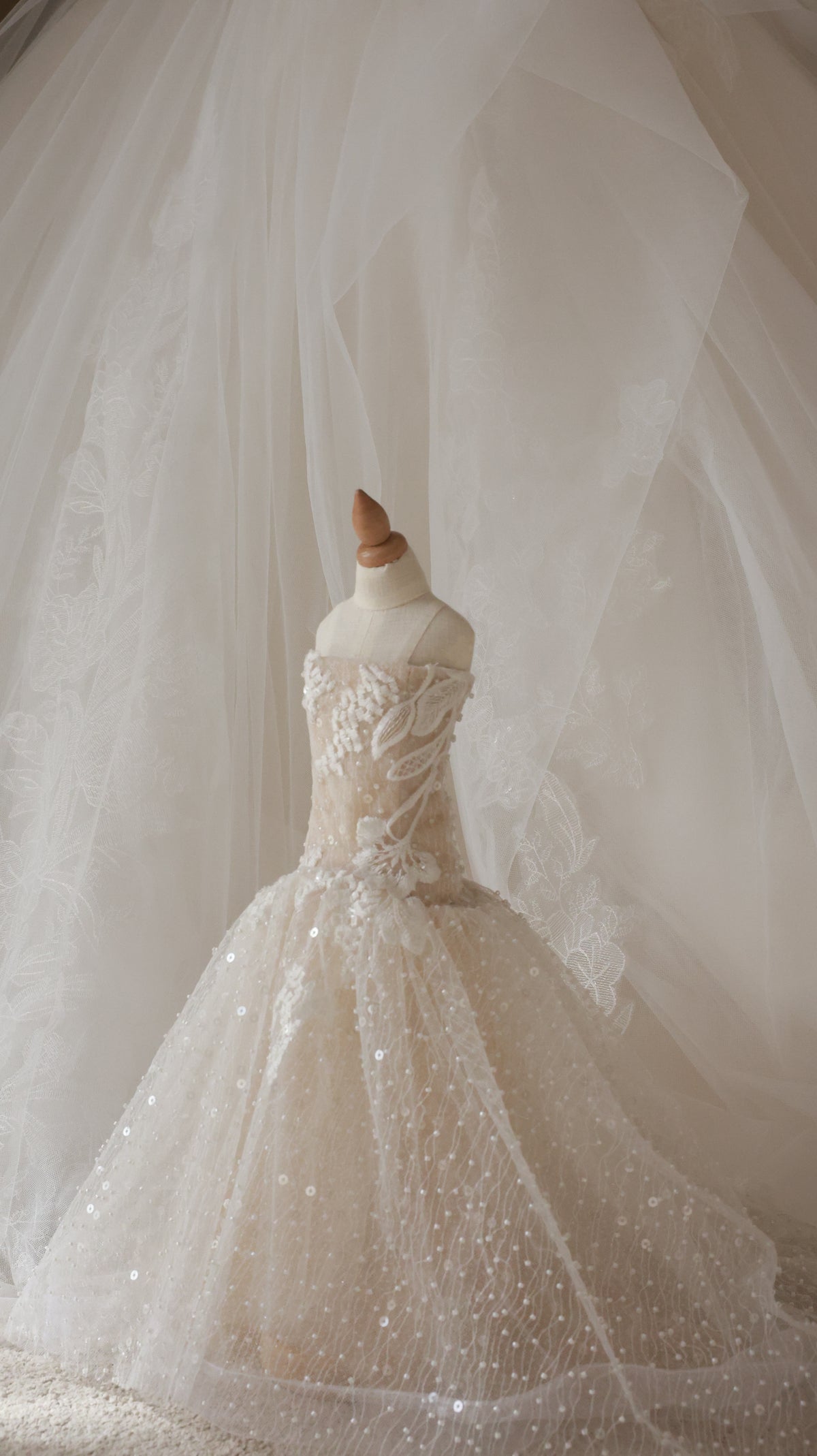 Close-up of a wedding dress with intricate details and a flowing train.