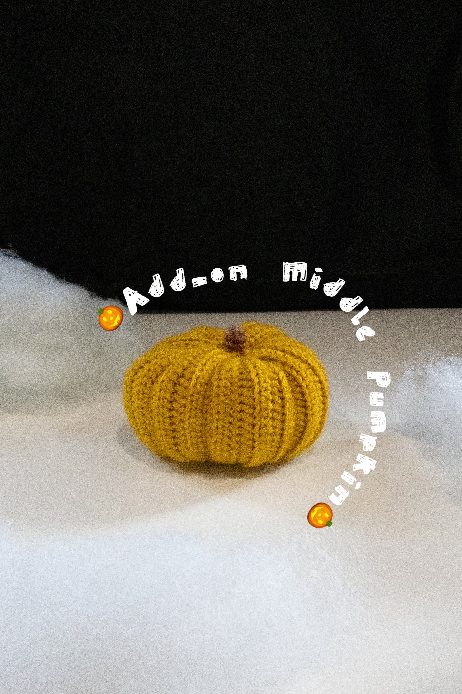 Knitted yellow pumpkin on a white surface with text overlay