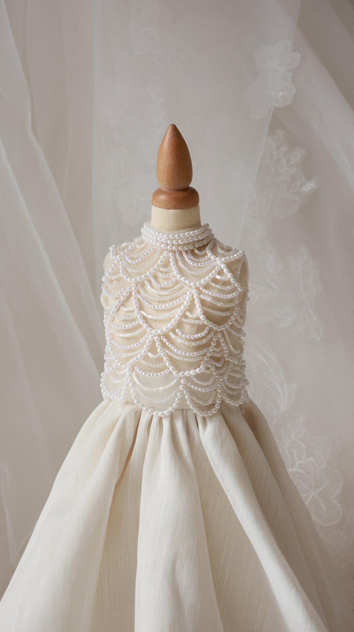 White lace dress on a mannequin with a neutral background